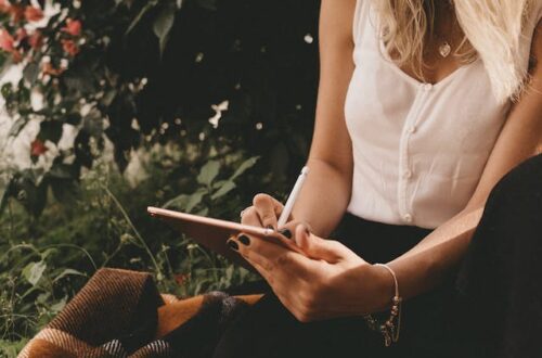 Woman relaxing on a comfy and cozy blanket writing a list.